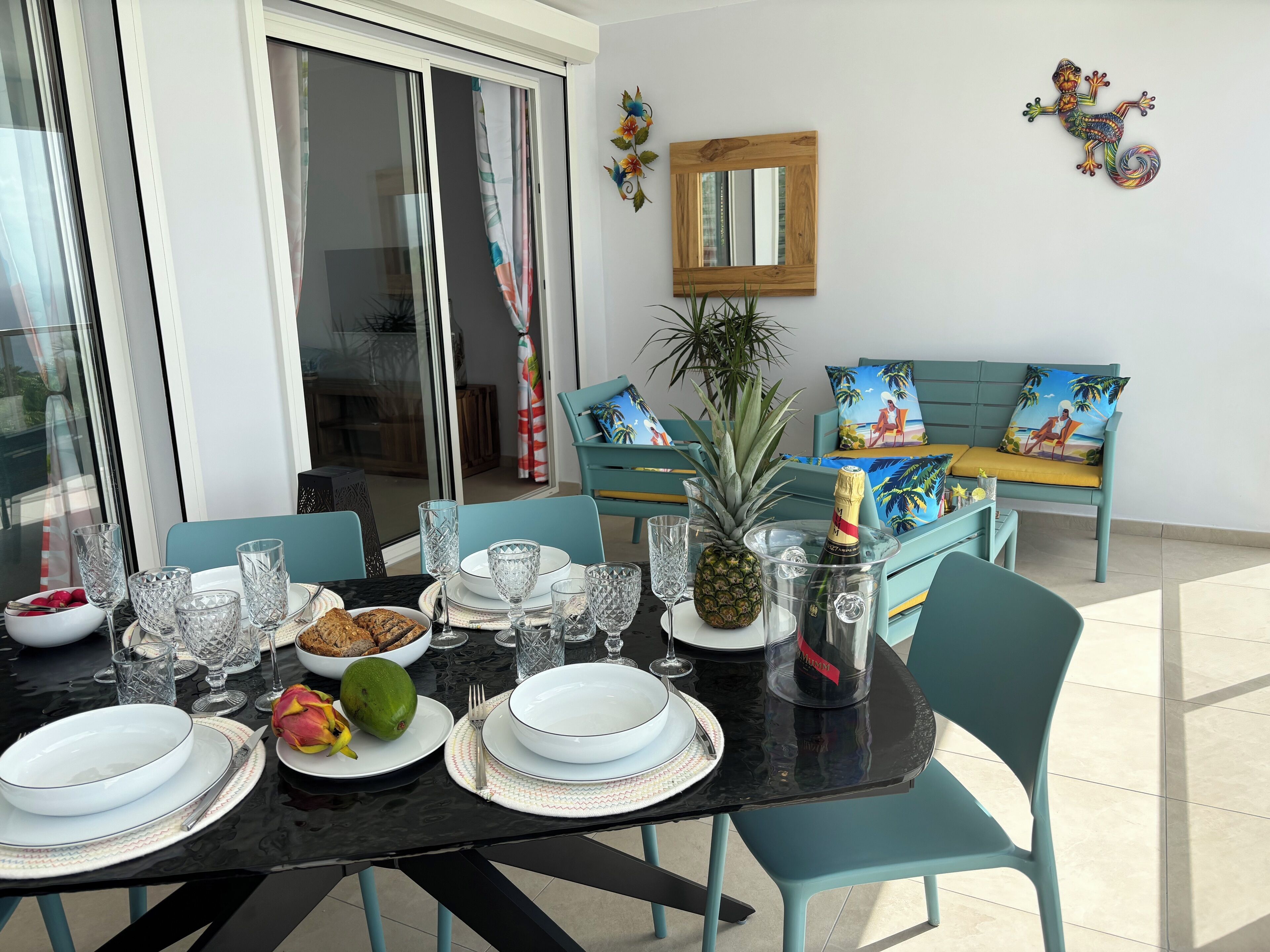 A dining table set with plates, glasses, and a pineapple centerpiece.