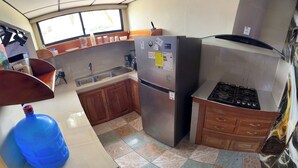 Cocina pequeña equipada con refrigerador, estufa y lavaplatos.