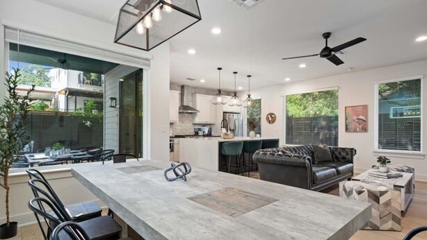 A modern kitchen with a central island, bar stools, and pendant lighting. - Spacious 5BR Central Austin Home w/Pool, Sleeps 13 (Austin)