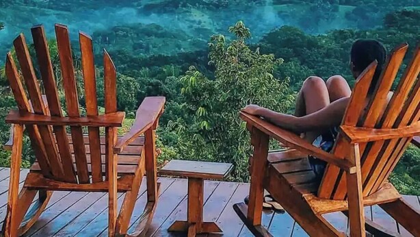 Two wooden chairs and a small table on a wooden deck overlooking a mountainous landscape. - Luxury Villa Ceibo - Exquisite, Private, Serene with Starlink (San Mateo)