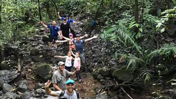 Um grupo de pessoas caminhando em uma área arborizada com um riacho.
