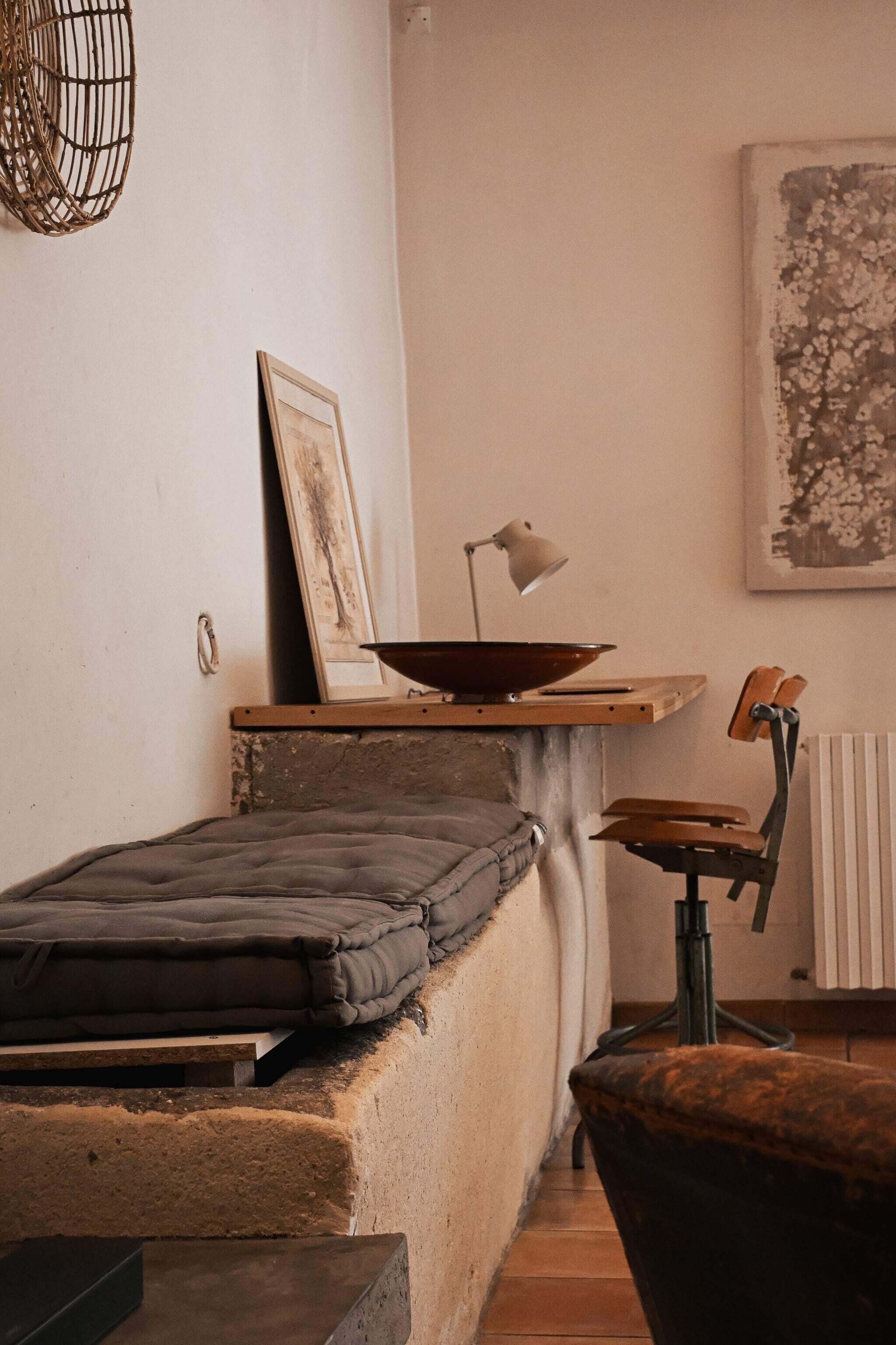 Una habitación acogedora con cama, una mesita de noche con lámpara, una silla y un radiador.