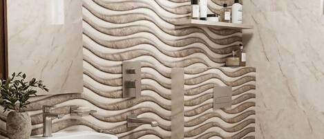 A modern bathroom with a wavy marble wall, a sink, a toilet, and a shower.
