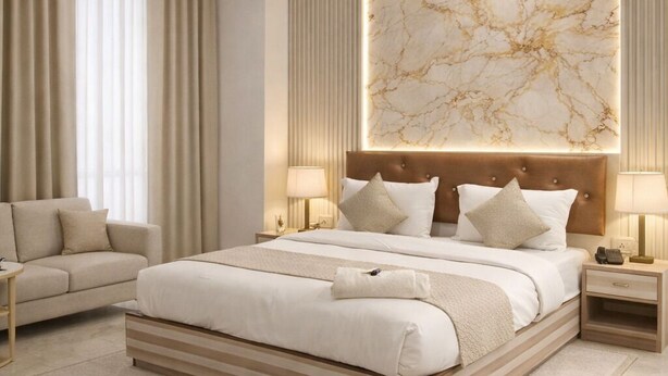 A modern bedroom with a large bed, a ceiling fan, and a marble wall. - Hotel The Best Delhi Airport (New Delhi)