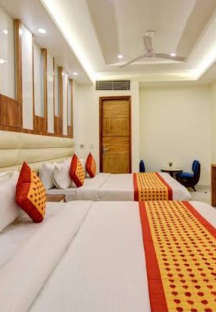 A hotel room with two beds, a desk, and a chair.