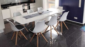 A modern kitchen with white cabinets, a black countertop, and a stainless steel range hood. - 85 m2 Ferienwohnung mit überdachtem Parkplatz und Außenstellplatz - Bergblick (Bürs)