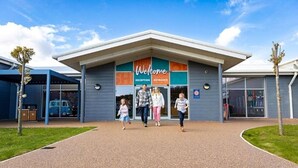 A building with a 'Welcome' sign, a reception area, and a covered entrance.