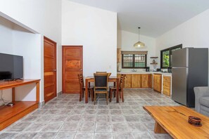 Eine kleine Küche mit Essbereich, einem Fernseher und einem Kühlschrank.