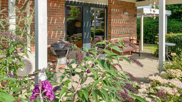 A covered patio area with a brick wall, a grill, and outdoor seating. - Lovely home in Tranekær with WiFi (Tranekær)