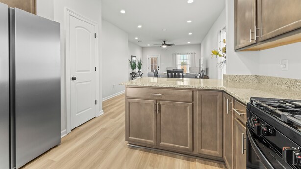 Una cocina moderna con una isla central, electrodomésticos de acero inoxidable y armarios de madera.
