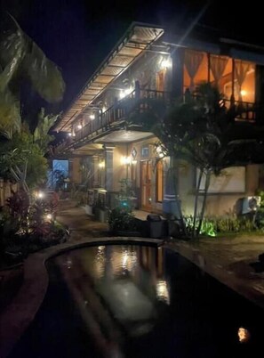 A two-story building with a balcony and a pool. - Menjangan Sari (Bali)
