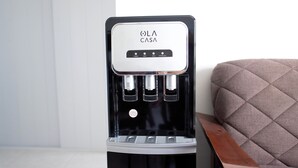 A black water dispenser with a logo, located in a room with a tiled floor and a cushioned bench. - Welcome to this 1 bed 1 bath condo with splendid pool view (Progreso)