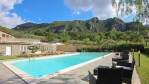 A swimming pool with lounge chairs and a stone building in the background. - Stunning home in Giungano (Giungano)