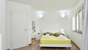 A bedroom with a bed, bedside tables, a mirror, and a window. - Stunning home in Giungano (Giungano)