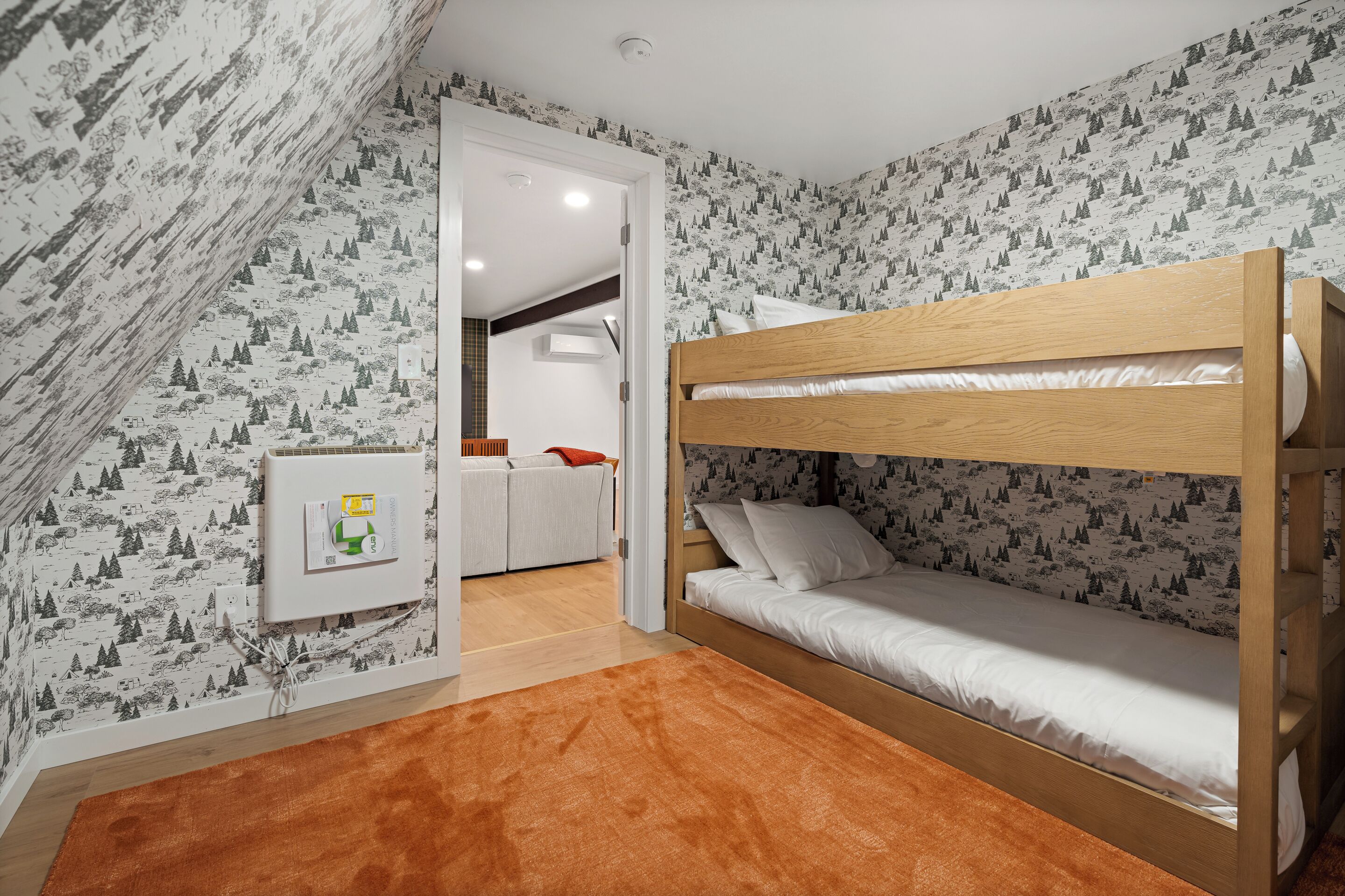 Habitación con literas, papel tapiz estampado, cabecero de madera y alfombra marrón.