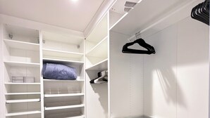 A walk-in closet with open shelving, drawers, and hanging space.