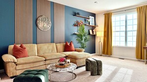 A living room with a sofa, ottoman, coffee table, and decorative items.
