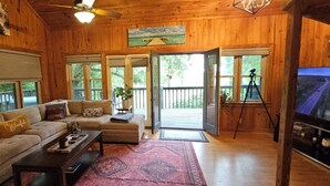 A cozy wooden interior with a sofa, coffee table, and a television.