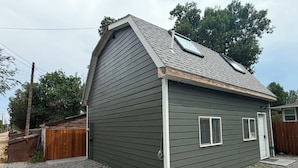 A single-story building with a sloped roof, a small porch, and a gravel driveway.