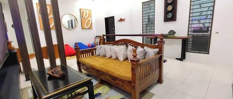 A room with a wooden bed, a small table, a TV, and a ceiling fan.