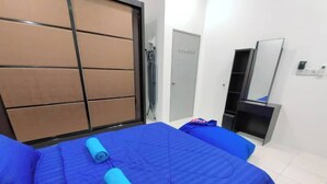 A hotel room with a bed, a wardrobe, a mirror, and a small desk. - Nur Hartamas Homestayportdickson (Port Dickson)