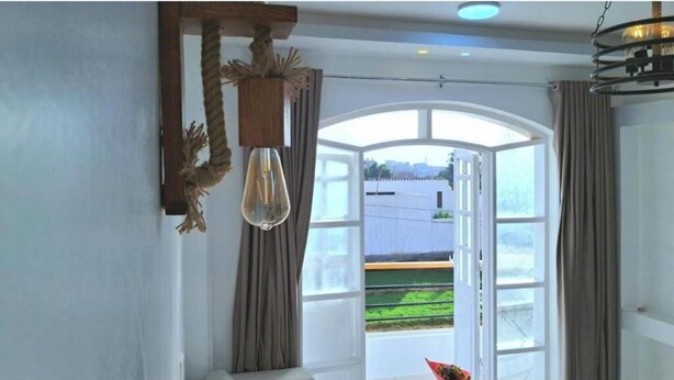 A room with a large window, a hanging light fixture, and curtains. - Superb 1-bedroom apartment #10 (Luxor Governorate)