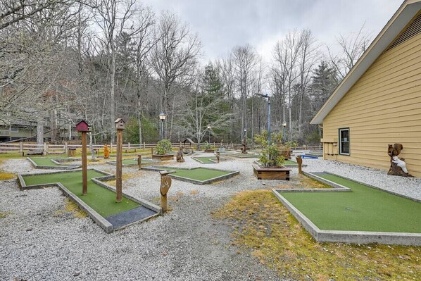 A miniature golf course with multiple holes, surrounded by trees and a wooden fence. - Mountain Views, Hot Tub & Resort Amenities in Sapphire, NC (Sapphire)