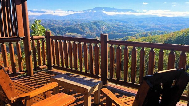 A wooden deck with a view of a mountainous landscape.