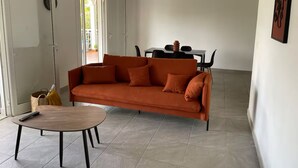 A living room with a sofa, a coffee table, and a dining table with chairs. - 3-bedroom villa - island center (Fort-de-France)