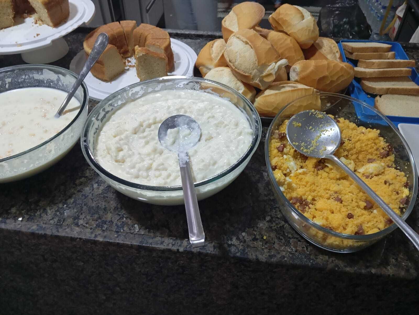 A buffet table with various food items including bread, a creamy dish, and a yellow crumbly dish.