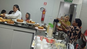 Ein Buffet mit verschiedenen Speisen und Getränken, ein Feuerlöscher und ein Schild, das einen Notausgang kennzeichnet.