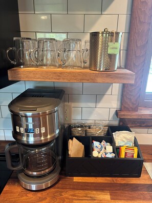 A kitchen with a coffee maker, a pot labeled 'Coffee', and a box of Twinings Earl Grey tea. - 3-bedroom modern mid century cabin! 
Hot tub, fire pit and lake front (Dry Ridge)