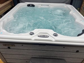 A Viking Spa hot tub with a control panel and a wooden deck surrounding it. - 3-bedroom modern mid century cabin! 
Hot tub, fire pit and lake front (Dry Ridge)