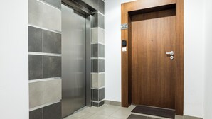 Un ascenseur et une porte en bois portant le numéro 148.