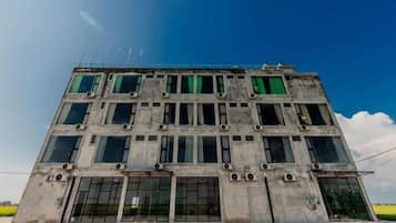 A multi-story building with a concrete facade, large windows, and visible air conditioning units.