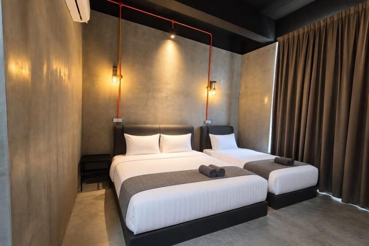 Ein modernes Hotelzimmer mit einem großen Bett, Nachttischen und Blick auf die Stadt.