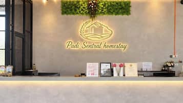 Un mostrador de recepción con un logotipo, diplomas enmarcados y una planta pequeña.