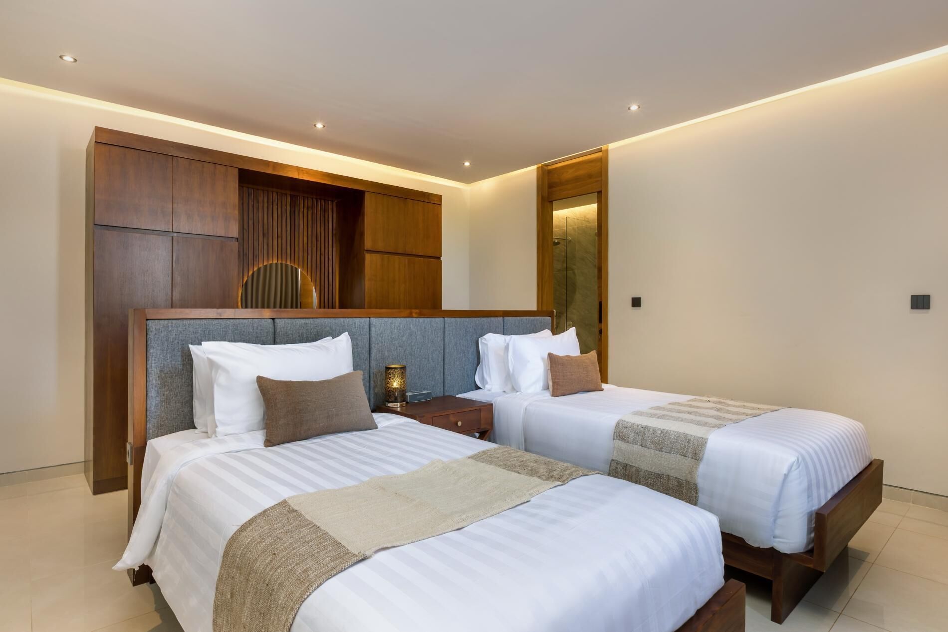 Ein modernes Hotelzimmer mit zwei Betten, Holz Kopfteilen und einem Einbauschrank.