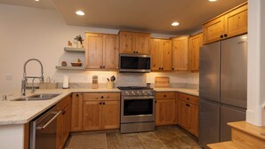 A modern kitchen with wooden cabinets, stainless steel appliances, and a granite countertop. - Spacious 3-bedroom townhome in Durango with mountain views, perfect for families. (Durango)