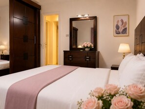 A hotel room with a bed, a dresser, a mirror, a nightstand, and a wall-mounted lamp.