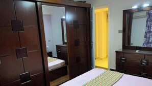 A bedroom with a bed, a wardrobe, and a mirror. - Casa De Horyea 2 - الميرغني (Cairo Governorate)