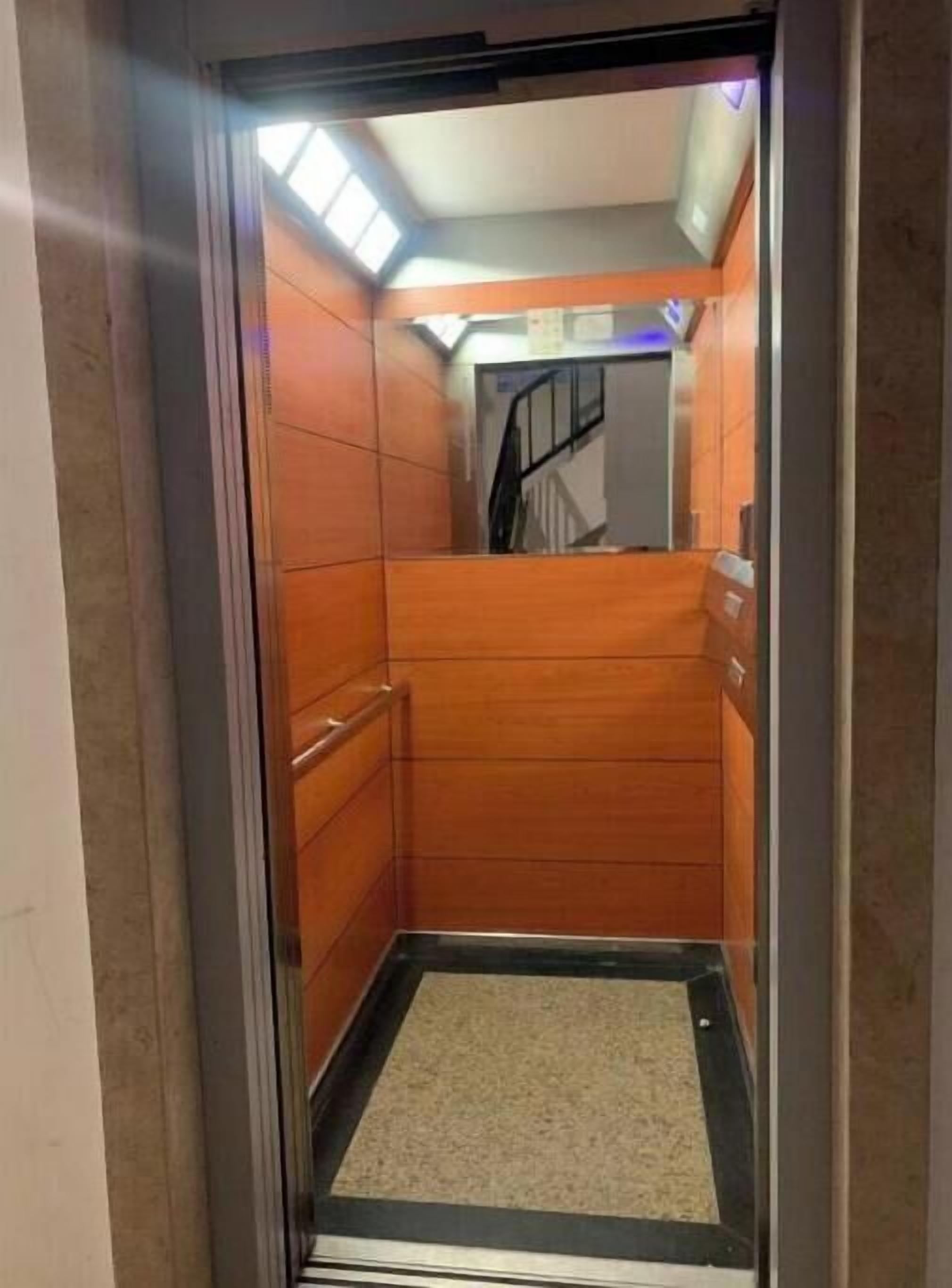 Un ascenseur avec des parois en bois et une structure métallique.