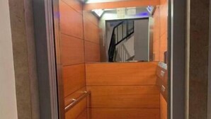 An elevator with wooden walls and a metal frame.