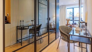 A modern living room with a glass partition, a dining area with a glass table, and a view of the city through large windows. - Stylish Flat with Workspace & Garage by HostWise (Porto)