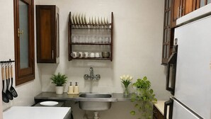 Une cuisine compacte équipée d’un évier, d’une cuisinière et d’un lave-linge encastré.