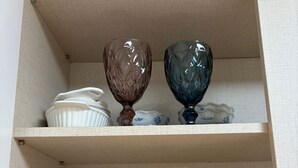 A cabinet with shelves containing glassware and dishes.