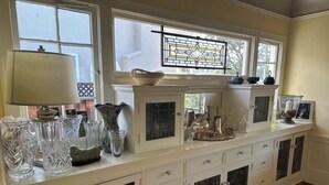 Una cocina con encimera blanca, armarios y una ventana con diseño de vitral.