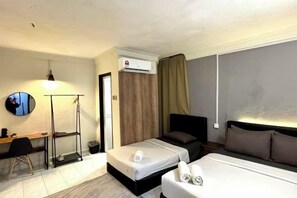 Habitación de hotel con dos camas, un escritorio, una silla, un equipo de aire acondicionado y un ventanal grande.