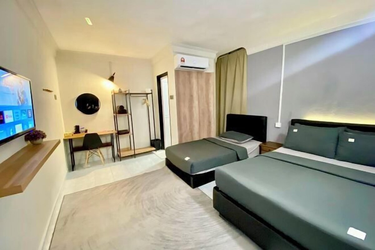 Una habitación de hotel con una cama, un escritorio, una silla, un televisor y un aire acondicionado.