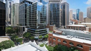 A modern urban skyline with high-rise buildings, including a distinctive glass structure and a cylindrical building.